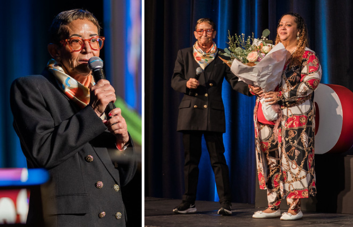 A photo of YWCA Seattle | King | Snohomish CEO Maria Chavez-Wilcox standing on stage with Candice, who is holding a flower bouquet.